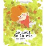 Couverture du livre 'Le goût de la vie' avec une illustration d'un enfant aux cheveux roux souriant parmi des feuilles vertes.