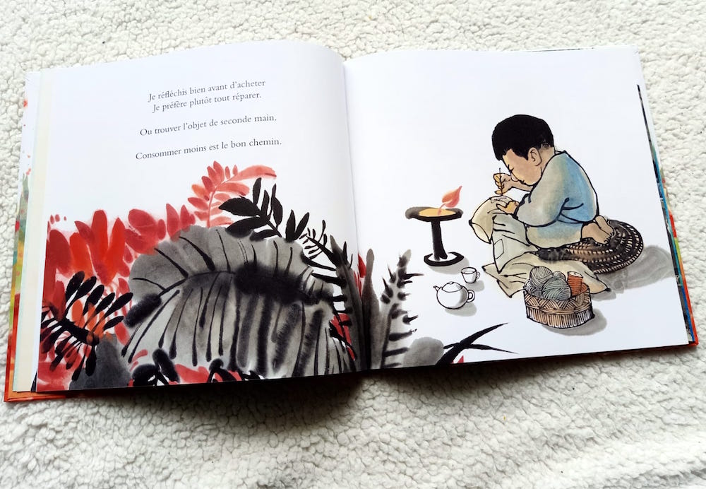 Page d'un livre illustré montrant un enfant assis à l'établi, réparant un vêtement, avec des éléments de couture et une bougie allumée, entouré de plantes colorées.
