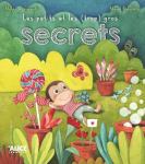 Couverture d'un livre illustré intitulé 'Les petits et les (gros) secrets', représentant un singe dans un jardin coloré avec des bonbons, des plantes et des fleurs.