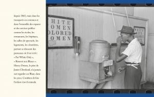 Un homme utilisant un distributeur d'eau dans un environnement ségrégué, avec des panneaux indiquant 'White Women' et 'Colored Women'.