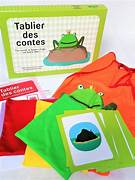 Un ensemble de jeu éducatif avec un tablier aux couleurs vives, des fiches illustrées comme une grenouille et une valise en carton portant l'inscription 'Tablier des contes'.