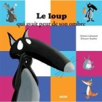 Couverture du livre 'Le loup qui avait peur de son ombre' avec un loup noir et des personnages colorés sur un fond de carrés.